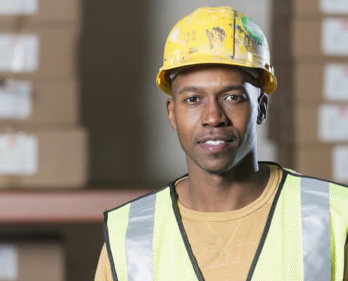 African American man (20s) wearing hardhat and safety vest (Credit: iStock)