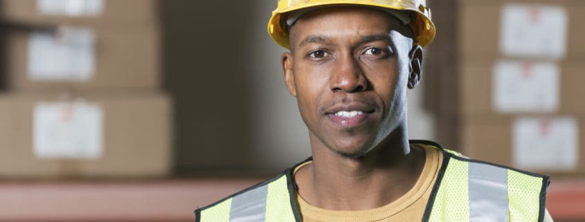 African American man (20s) wearing hardhat and safety vest (Credit: iStock)