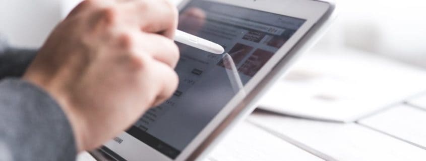 Individual filling out an online form on a tablet. Credit: Pexels