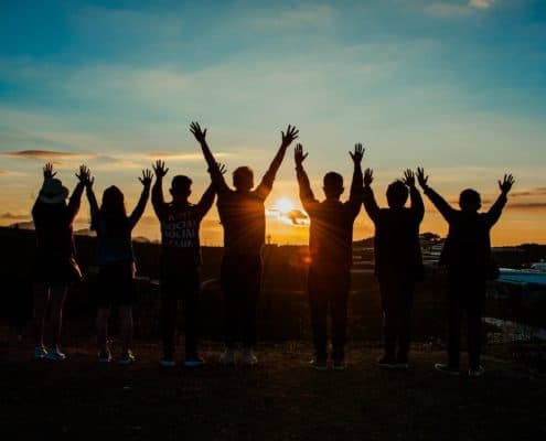 Group of happy people posing during a sunset.