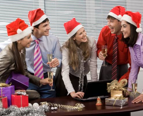 Photo of laughing co-workers interacting during corporate party in office
