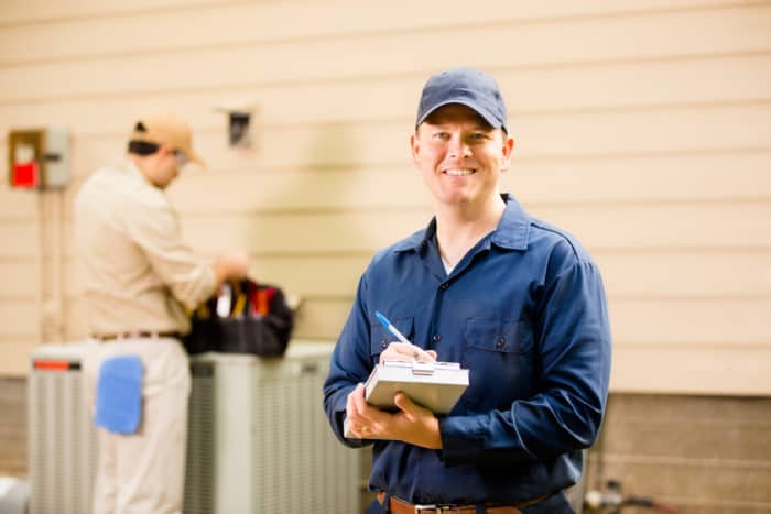 Image of a maintenance person holding a notepad and smiling.